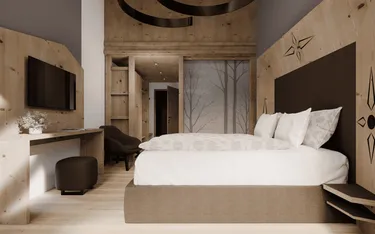 Modernes Hotelzimmer in Holzoptik mit Bett, Wanddeko, Fernseher, Schreibtisch und Sitzgelegenheit in der Alta Badia, Dolomiten Region.